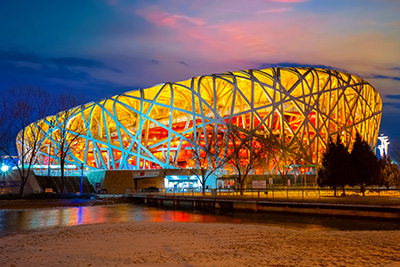  The Bird’s Nest National Stadium in Beijing illuminated at dusk, showing the intricate steel lattice that required advanced digital coordination tools during design and construction.
